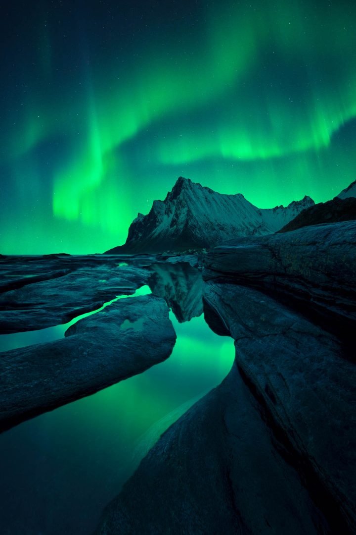 green northern light and reflection in water