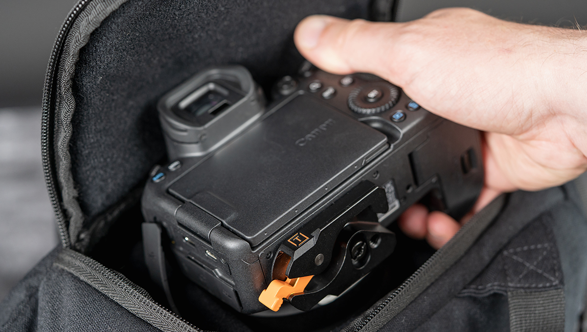 A Canon R6 with the Tether Tools LeverLock Plate being inserted into a bag