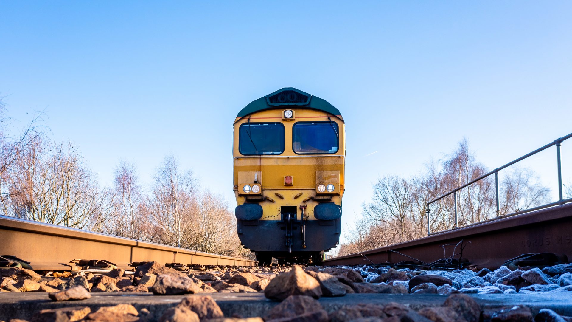 A point of view image of the front of a freight locomotive moving towards a person on the railway line in a suicide or occupational safety concept
