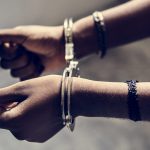 Closeup of arrested female hands with handcuffs