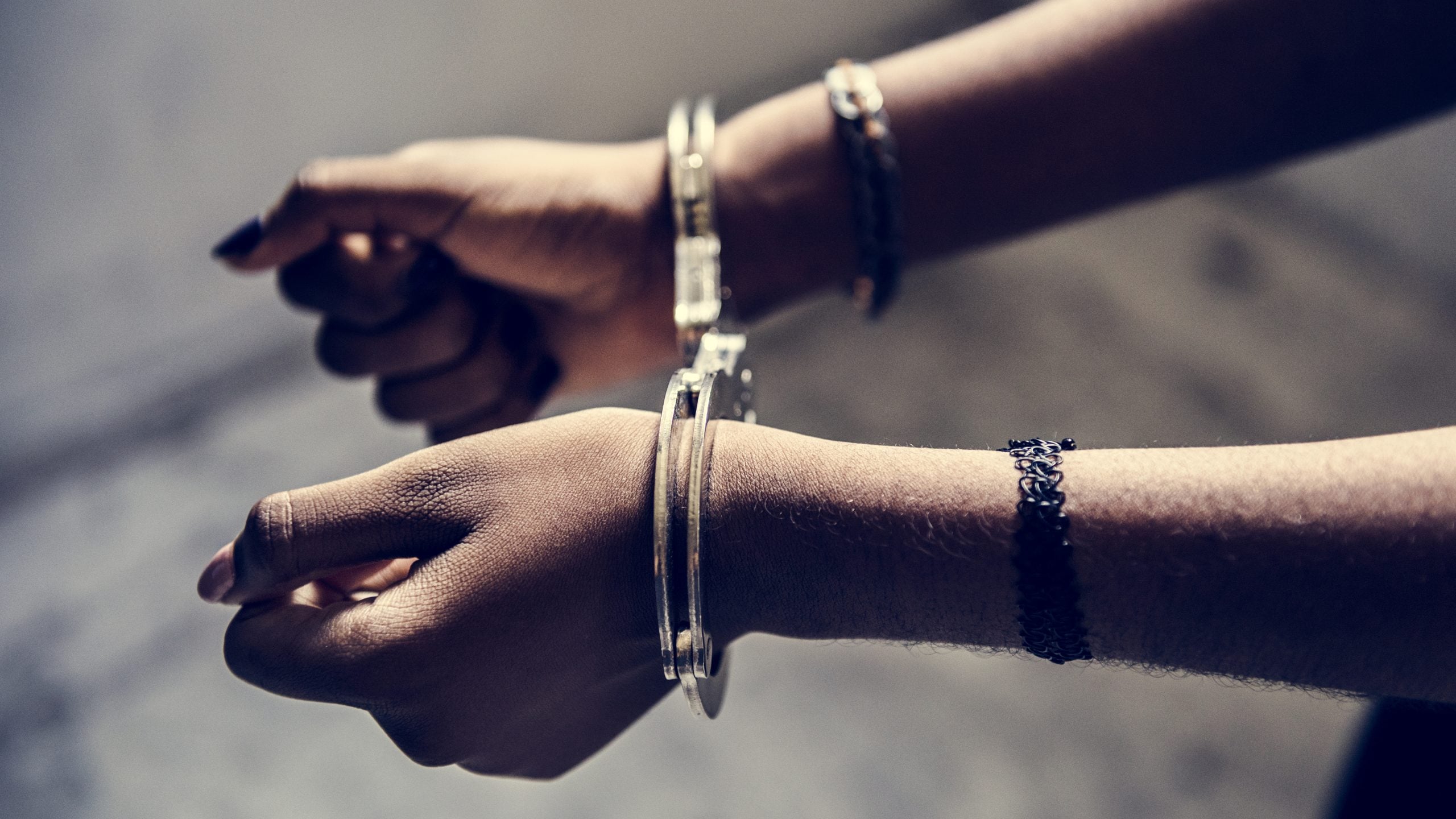 Closeup of arrested female hands with handcuffs