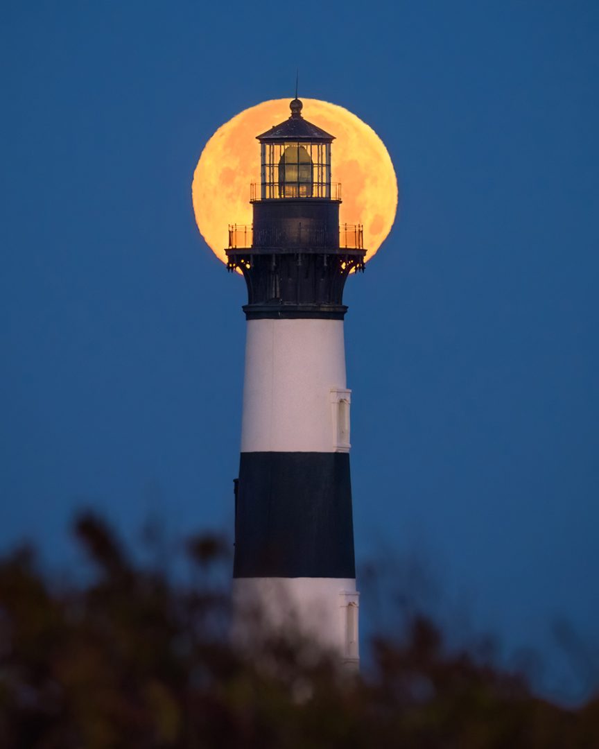 Wolf moon rising behind Bodie lighthouse