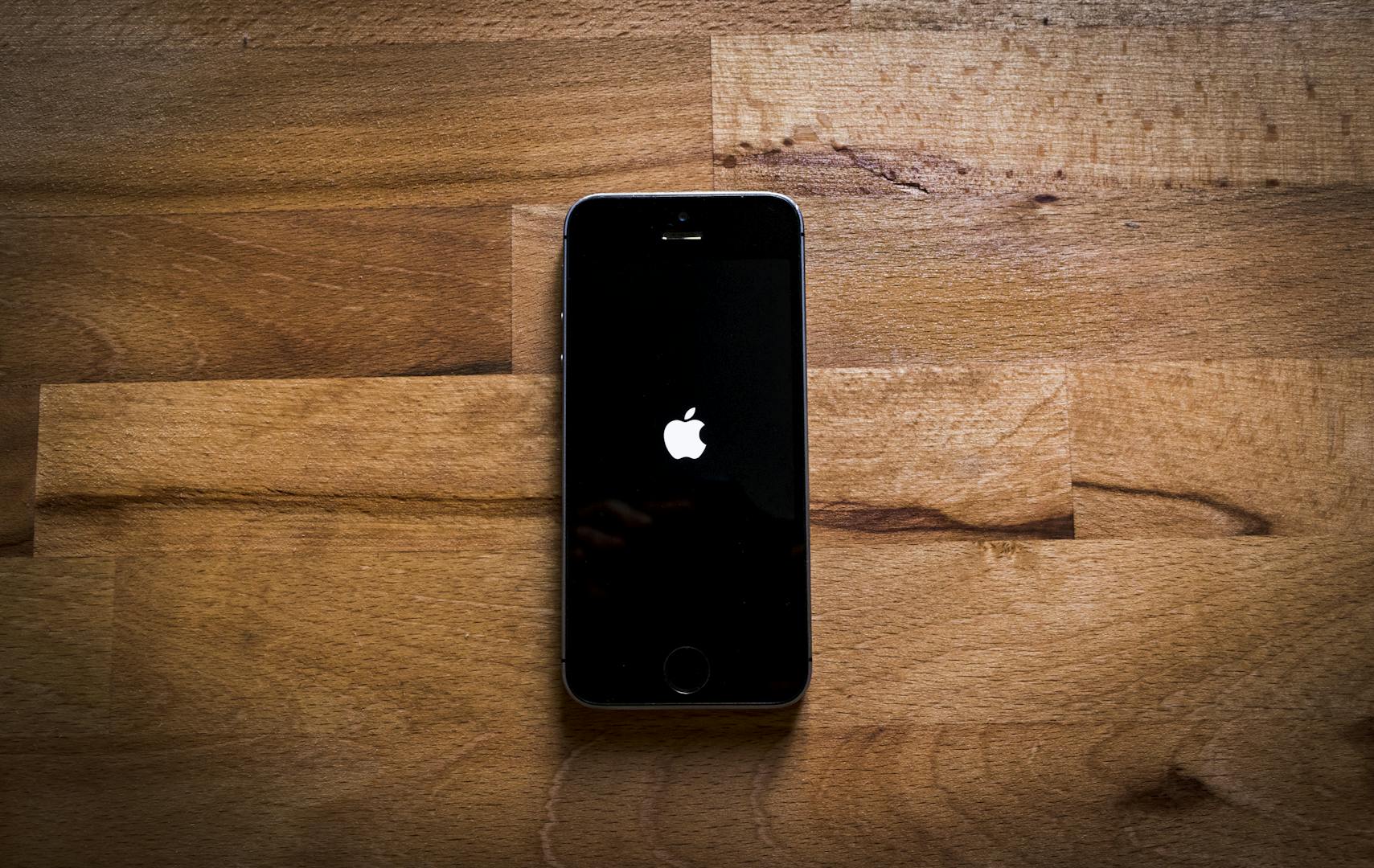 Close-up of a smartphone on a textured wooden surface, featuring a sleek design.