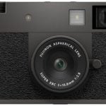 Front view of the FUJIFILM X-Half digital camera, showcasing its retro-inspired design, fixed lens, and textured black body with viewfinder.