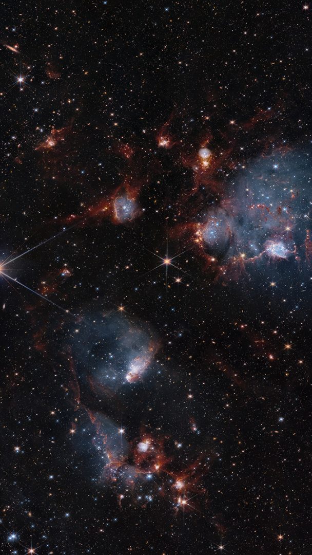 A vast network of stars, gas, and dust is strung among a duo of star clusters in this combined image from NASA’s Hubble and Webb space telescopes. Credit: NASA, ESA, and C. Lindberg; Processing: Gladys Kober