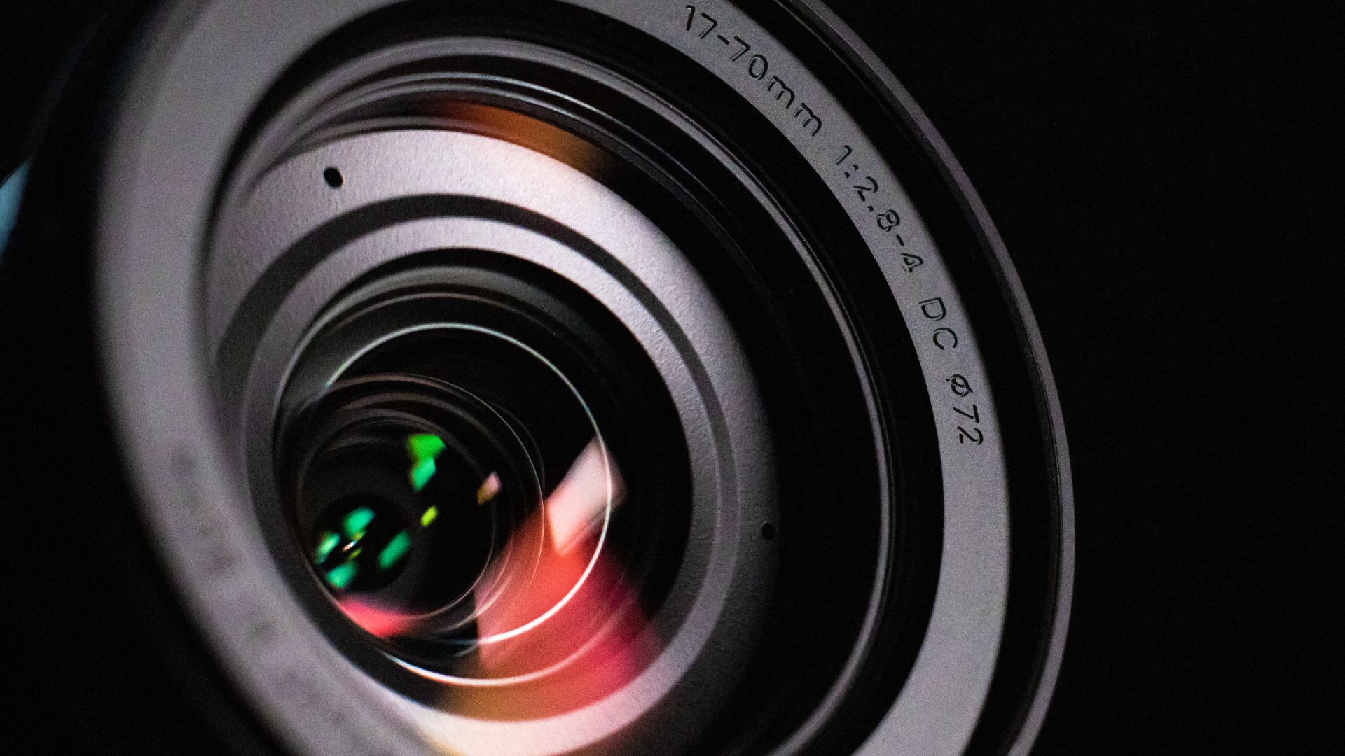A close-up shot of a camera lens with intricate reflections, showcasing the precision and detail essential for capturing microscopic images with clarity and accuracy.