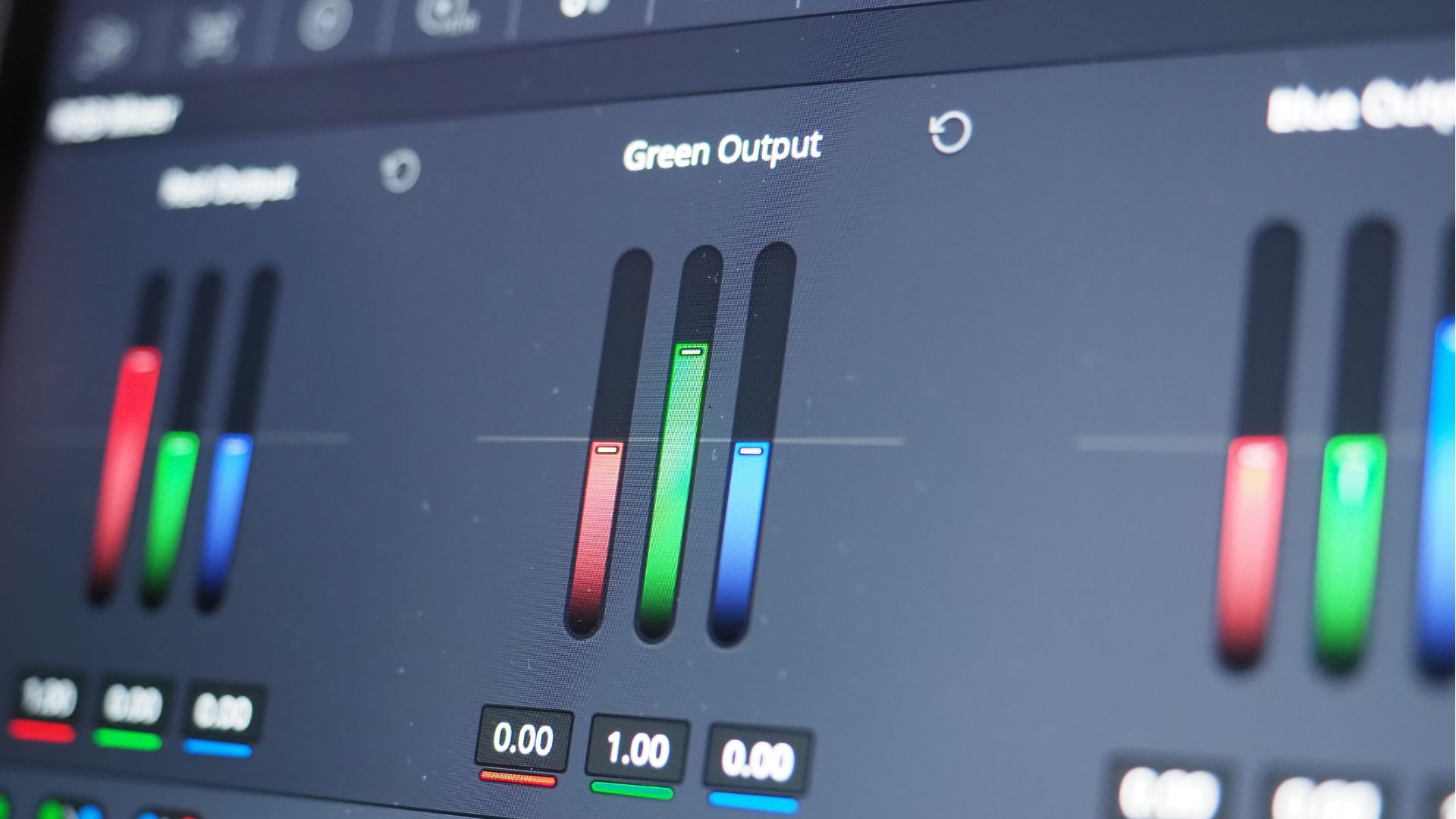 Close-up of color correction settings on a photo or video editing software, with sliders for adjusting the red, green, and blue output channels to enhance image colors.