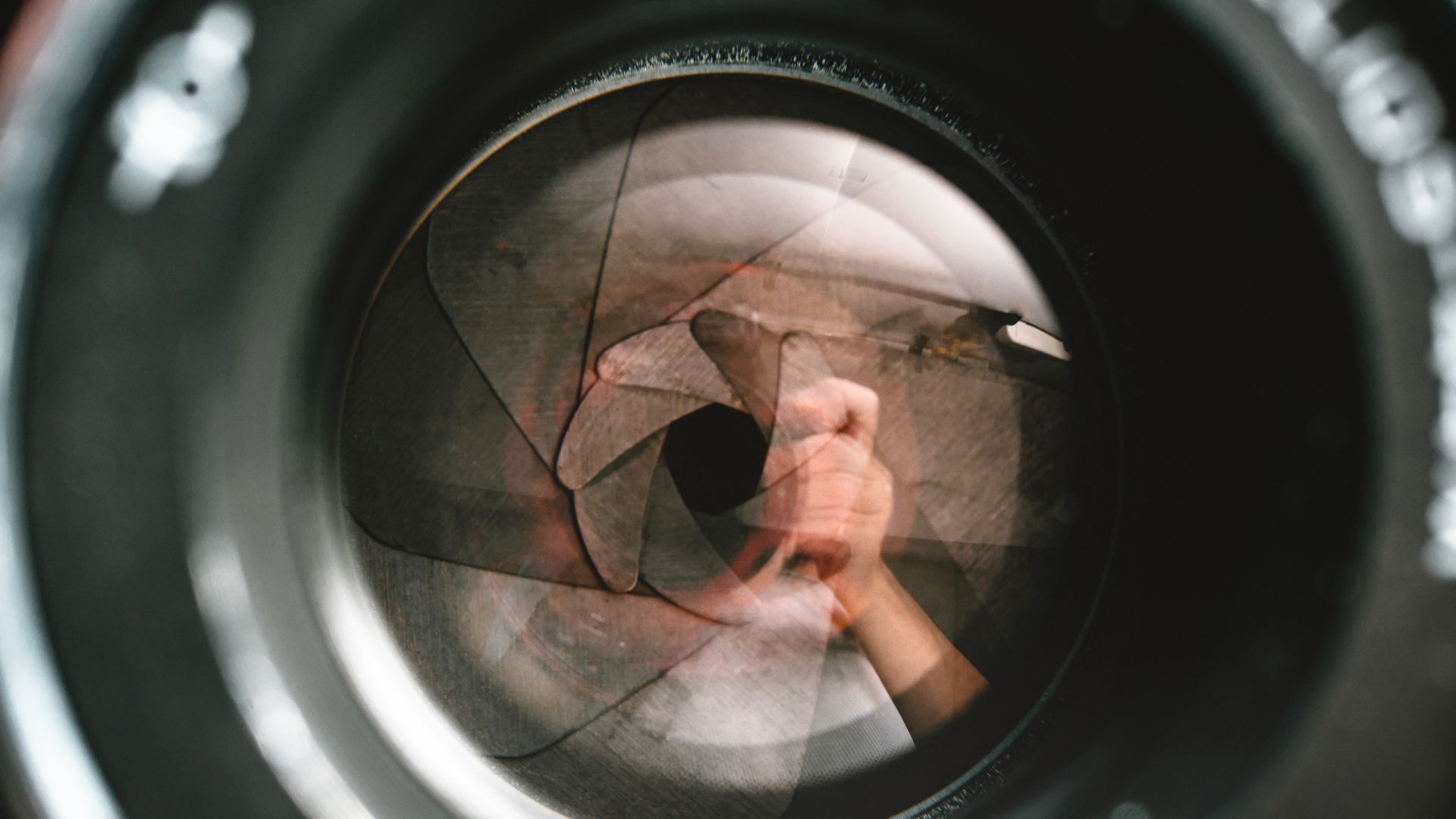Close-up view of a professional camera lens, highlighting its sleek design, intricate focus and zoom rings, and lens markings, showcasing its high-quality construction and optical capabilities.