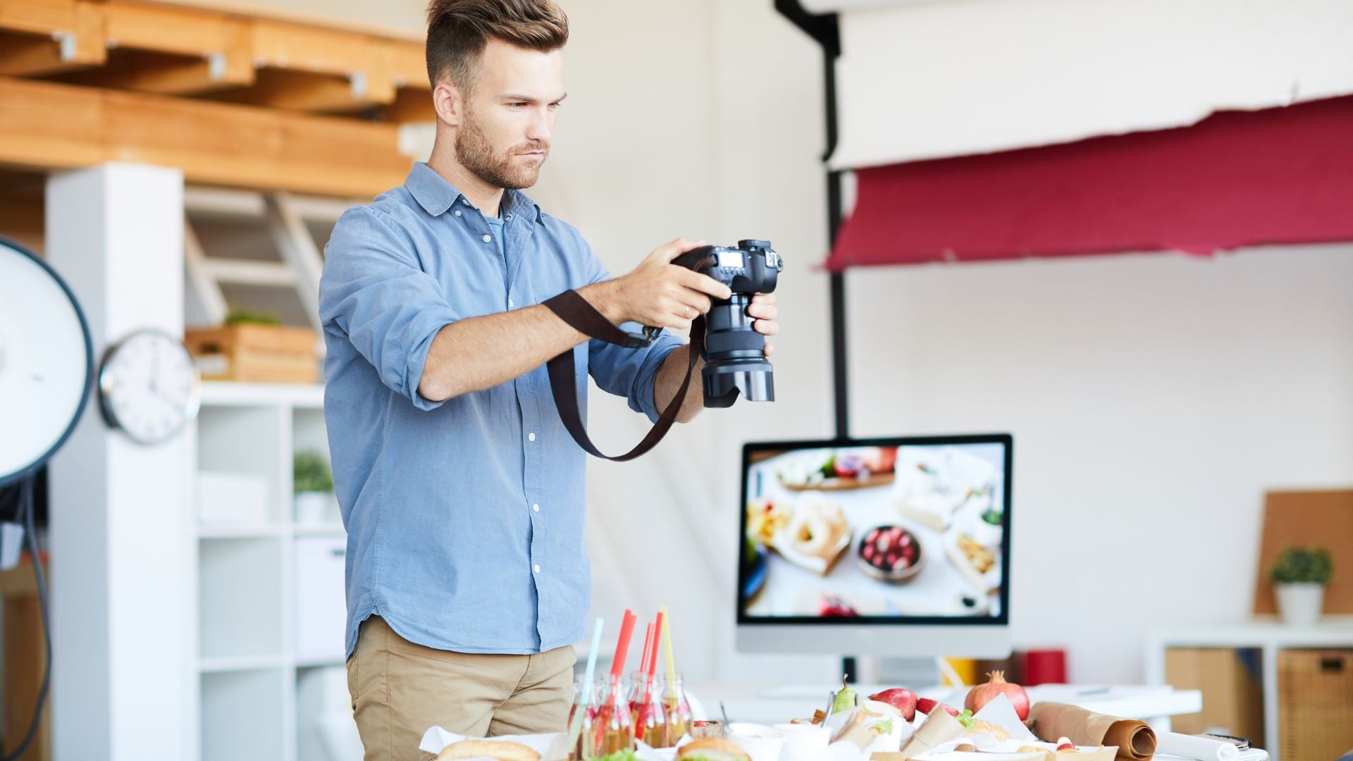 A photographer capturing a beautiful food scene with various dishes, while adjusting the camera settings in a bright studio environment.