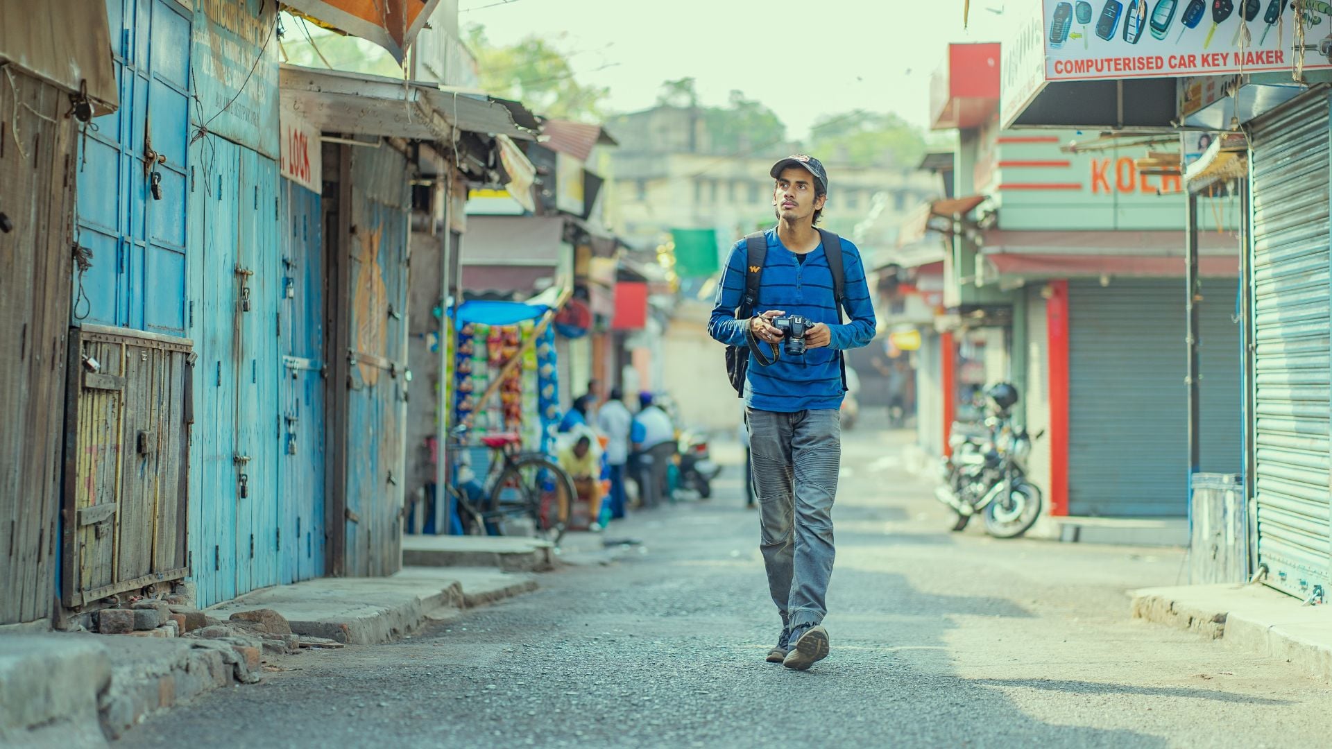 A person strolling down a sunlit street, captured in street photography, with vibrant city elements.