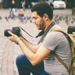A person in action, taking a photograph in the bustling street, exemplifying street photography style.