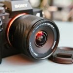 The Viltrox AF 14mm F4 Air lens paired with the Sony a7III on a blue table.