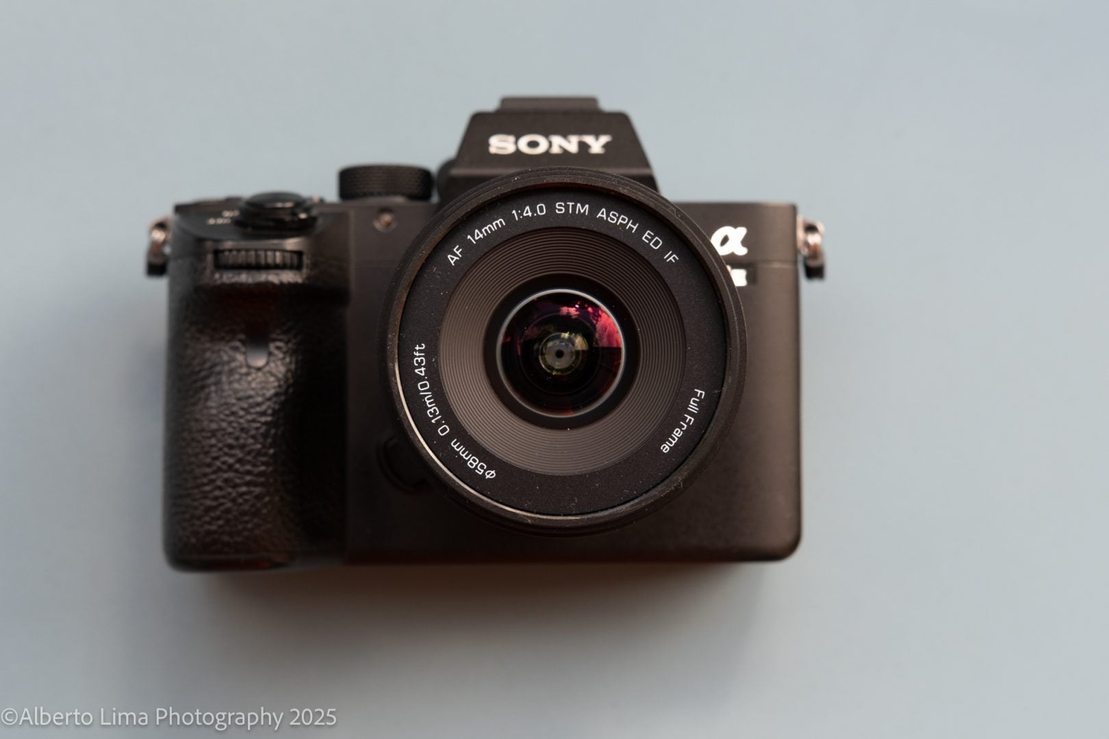 The Viltrox AF 14mm F4 front element against a blue backdrop. 