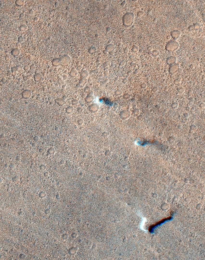 A colour satellite image of Mars shows several faint, swirling dust devils. Credit: ESA/TGO/CaSSIS