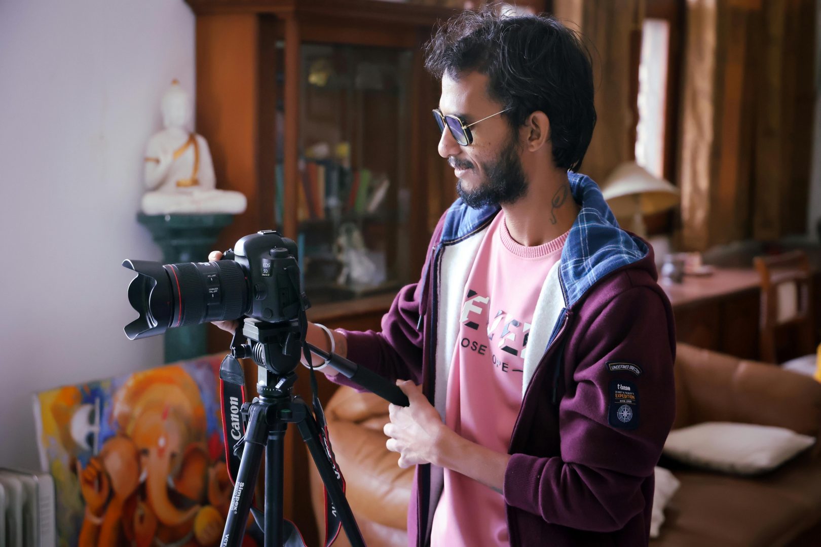 A man using a camera on a tripod.