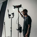 A man arranging the lighting inside a studio.