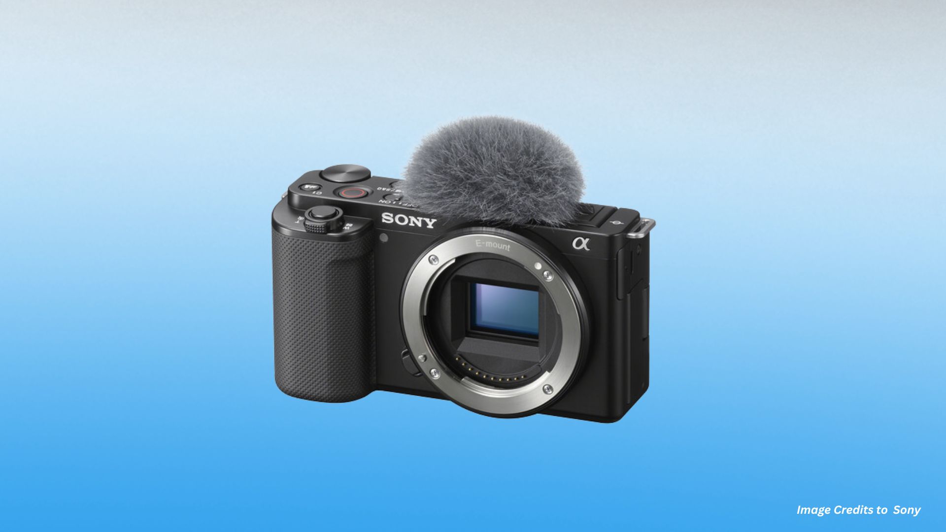 Front view of Sony ZV-E10 camera showing Alpha logo, E-mount visible sensor, textured grip, external shotgun microphone, recording buttons, and compact vlogging body.