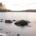 Experience the serene effects of long exposure on the ocean, where the waves gently blur and smooth over rocks, creating a peaceful, ethereal landscape.