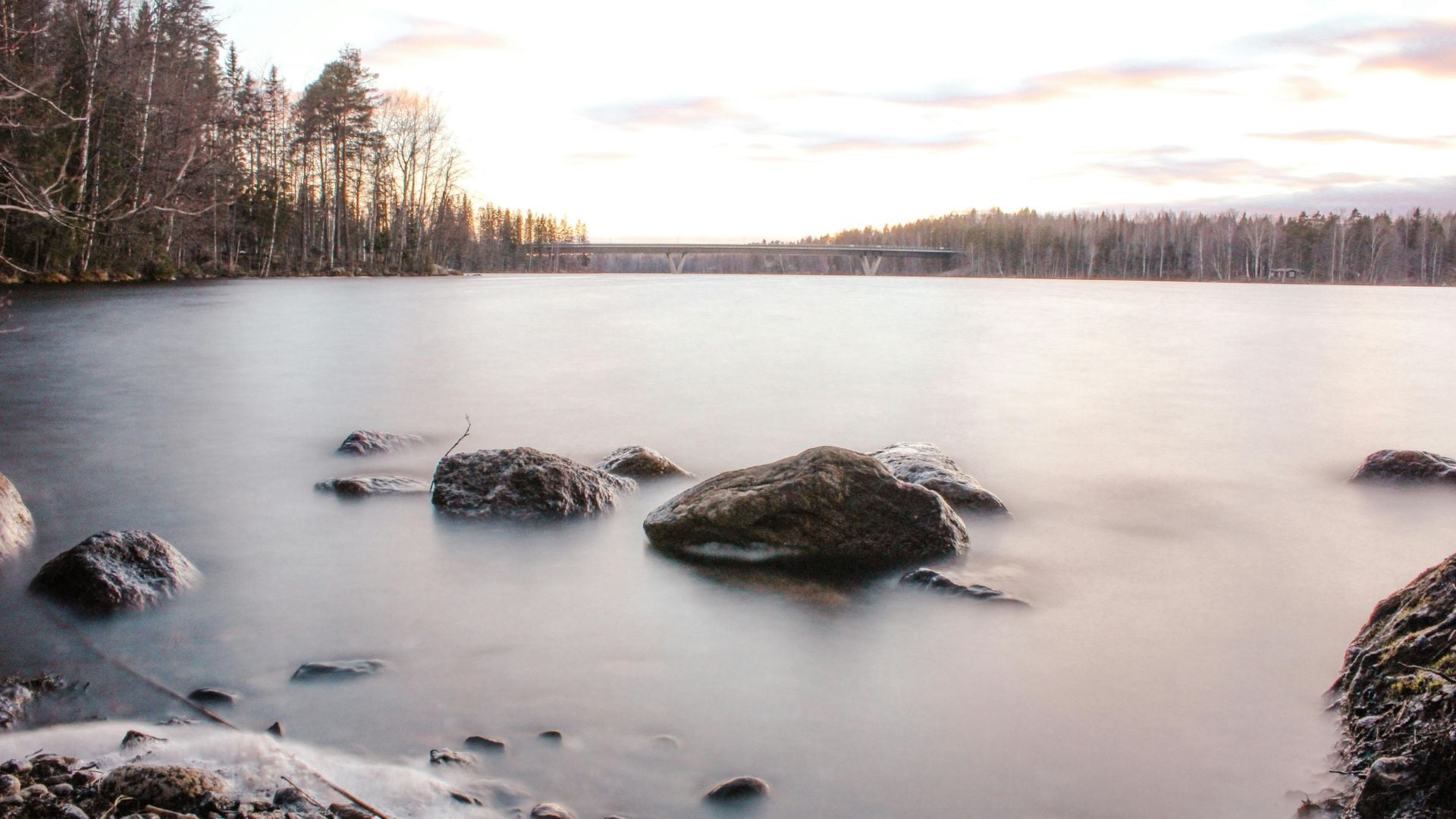 Experience the serene effects of long exposure on the ocean, where the waves gently blur and smooth over rocks, creating a peaceful, ethereal landscape.