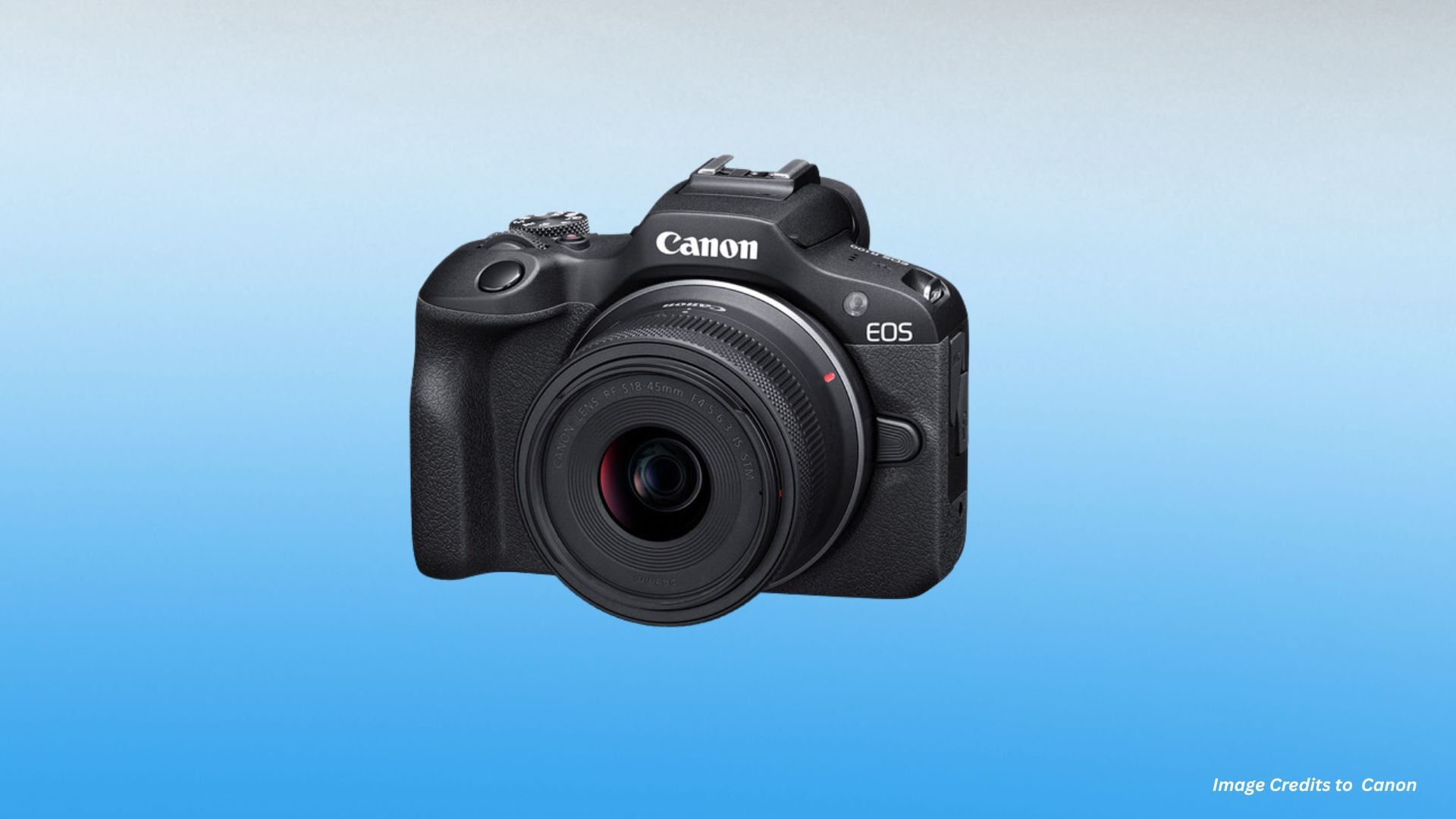 Close-up front angled view of Canon EOS R100 camera body with RF-S 18-45mm lens showing Canon and EOS branding with deep textured grip.