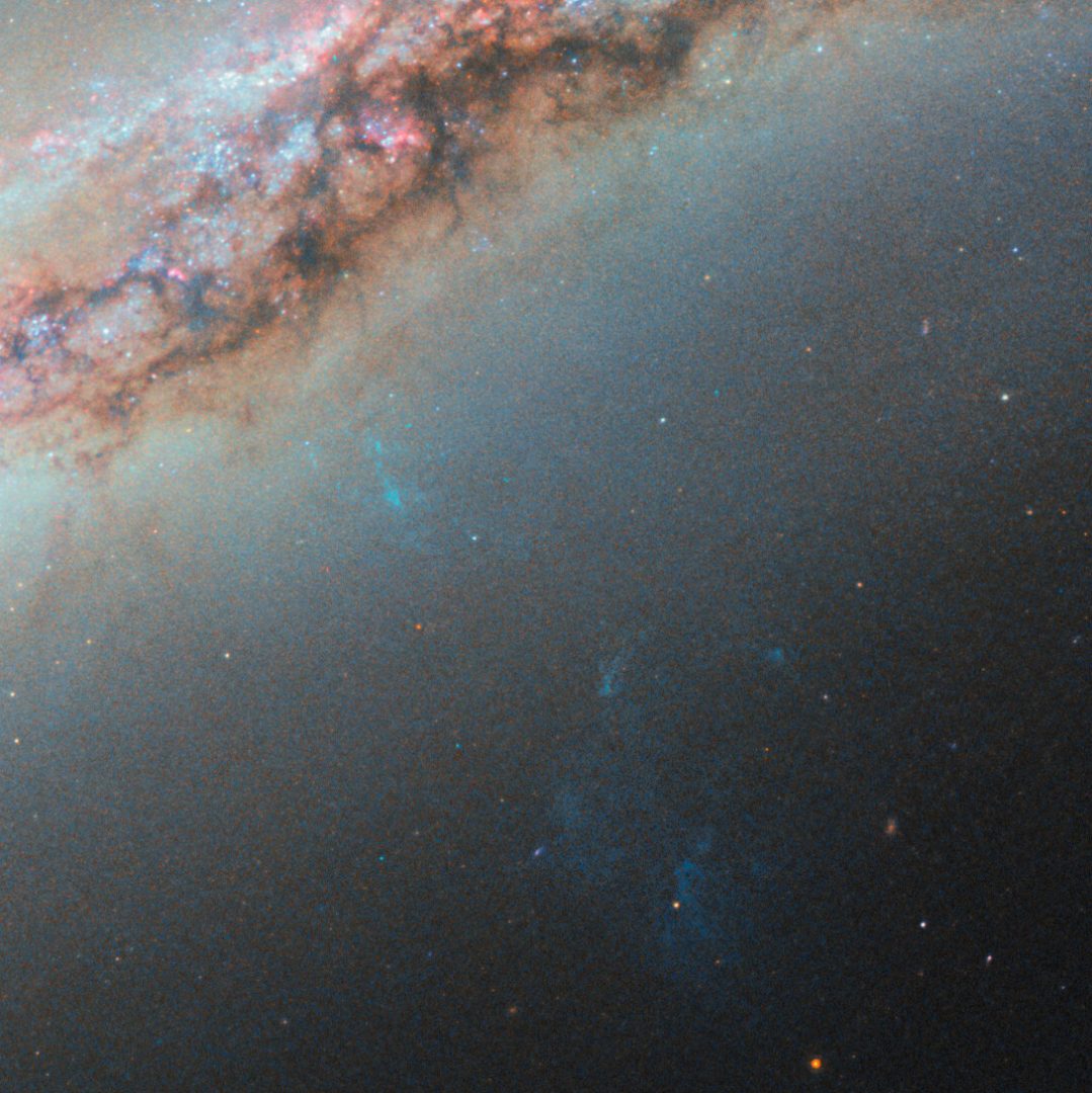A bluish plume of gas also extends from the galaxy’s core. Credit: ESA/Hubble & NASA, S. Veilleux, J. Wang, J. Greene