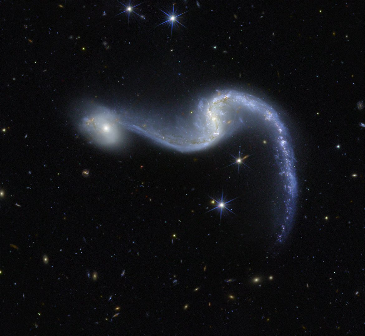 An image of space made by the Euclid telescope shows a bright barred spiral galaxy with two sweeping arms glowing in shades of blue and white against a deep black background dotted with stars. Credit: ESA/Euclid/Euclid Consortium/NASA, image processing by the Euclid Science Ground Segment and M. Schirmer (MPIA)