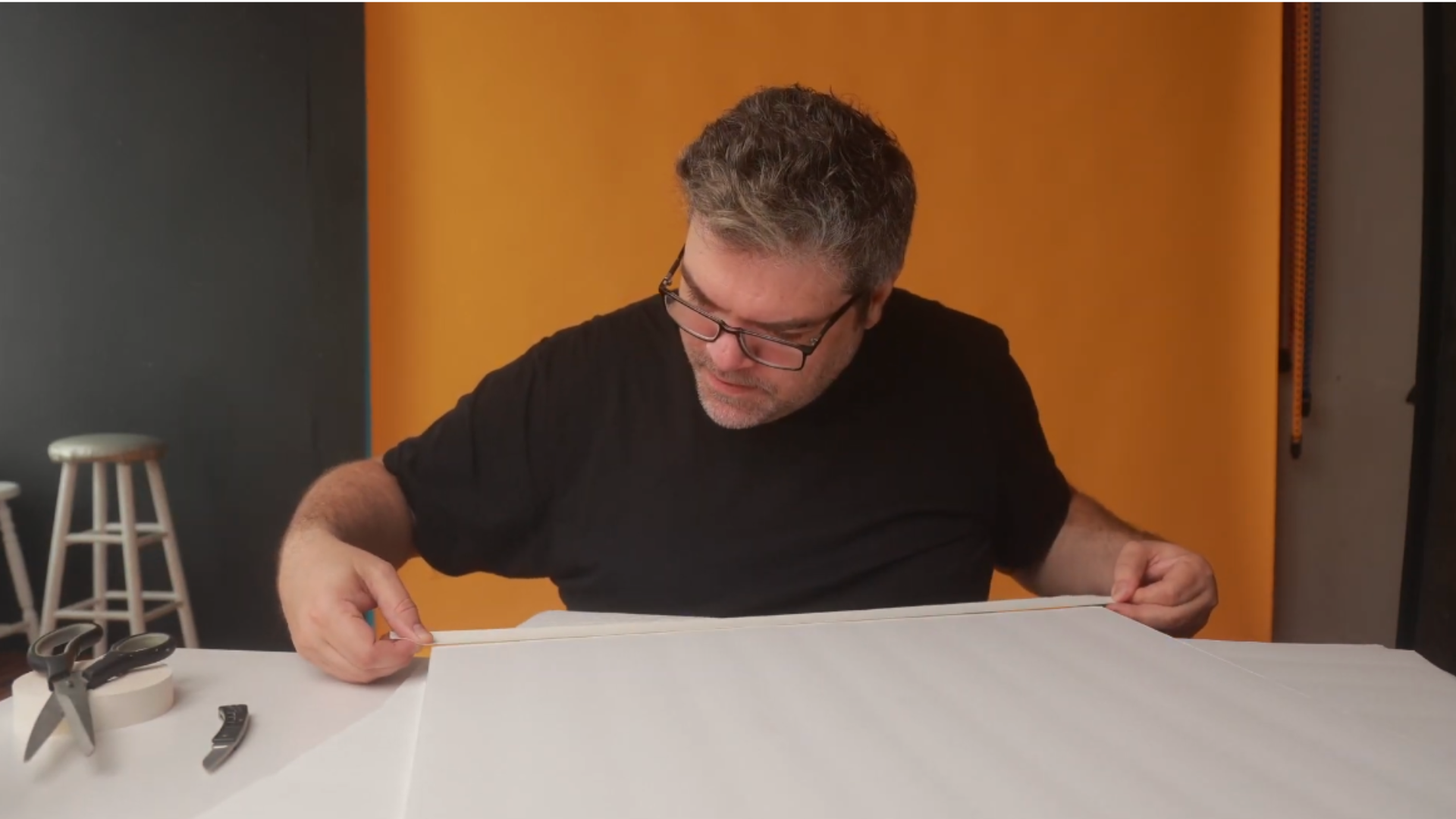 The first step in building your DIY V-flat, focusing on securely taping all the panel edges to ensure stability and durability during use.