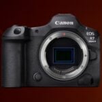 Canon EOS R7 Mark II full-frame mirrorless camera without lens showing RF mount, full-frame sensor, textured grip, and body controls on dark red studio background