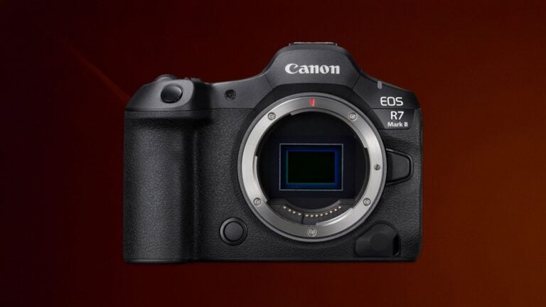 Canon EOS R7 Mark II full-frame mirrorless camera without lens showing RF mount, full-frame sensor, textured grip, and body controls on dark red studio background