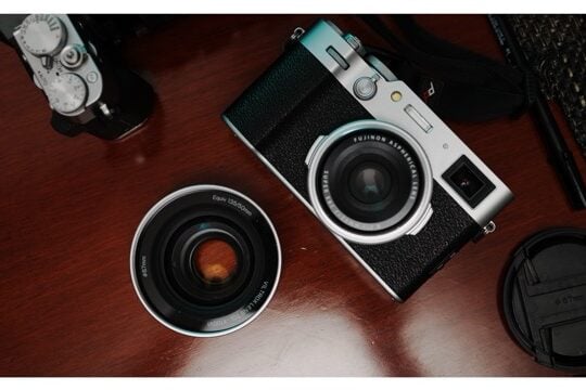 The Viltrox TCL-X100VI sits next to a Fujifilm X100VI and another camera.