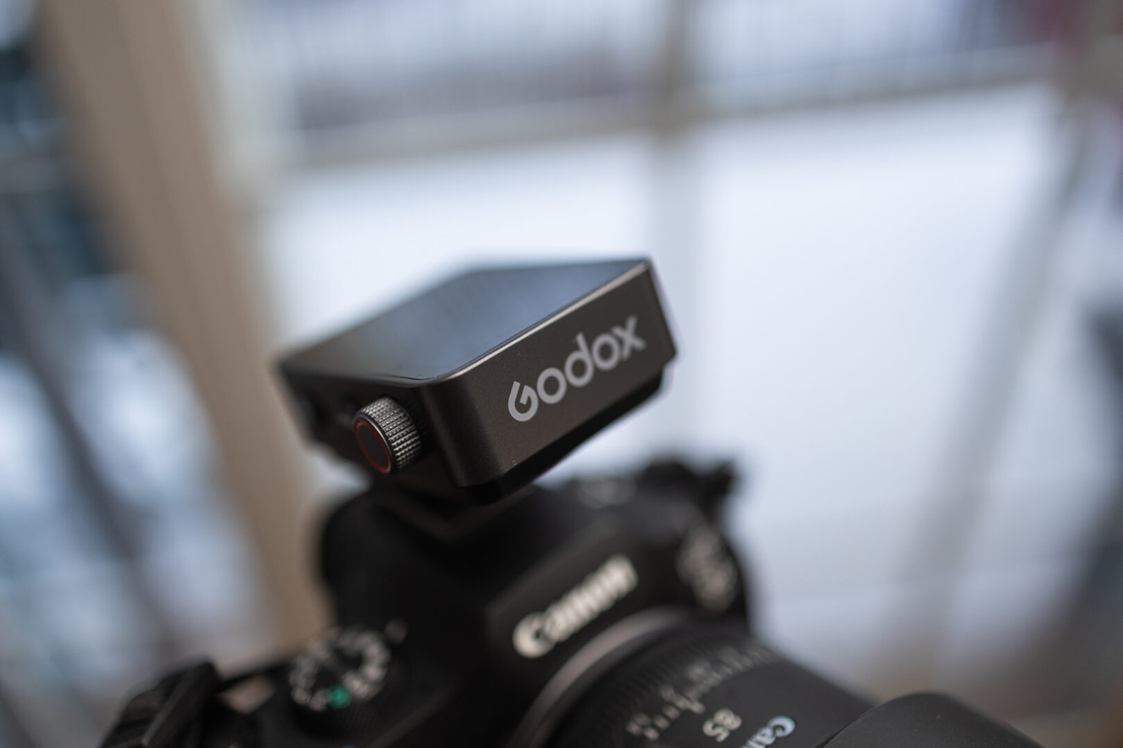 The Godox X3 Pro Trigger sits on top of a Canon Camera.