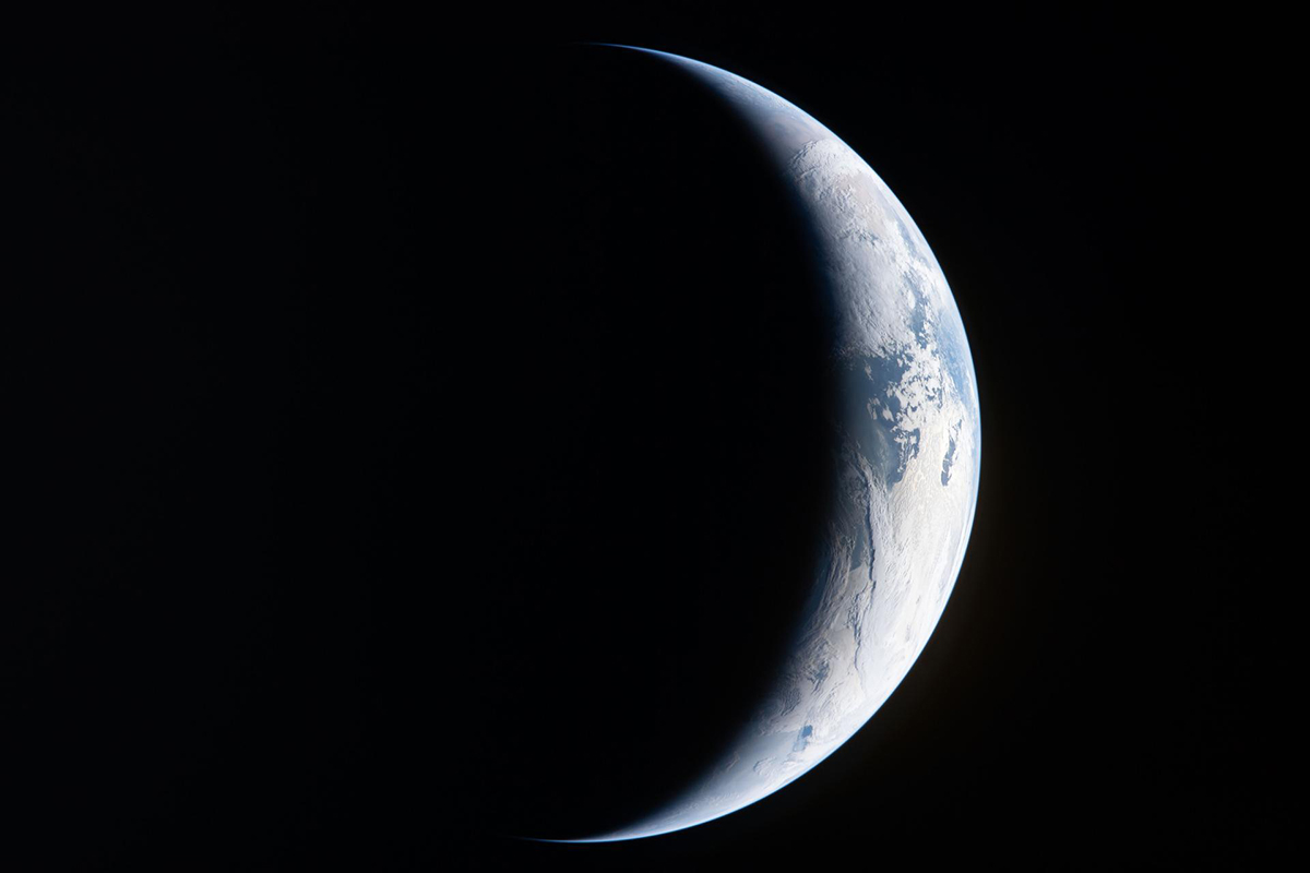 A sliver of Earth is illuminated against the blackness of space. Credit: NASA