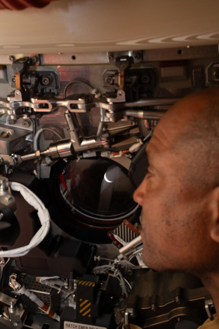 Artemis II pilot and NASA astronaut Victor Glover peers out one of the Orion spacecraft's windows, looking back at Earth ahead of the crew's lunar flyby on April 6, 2026. Credit: NASA
