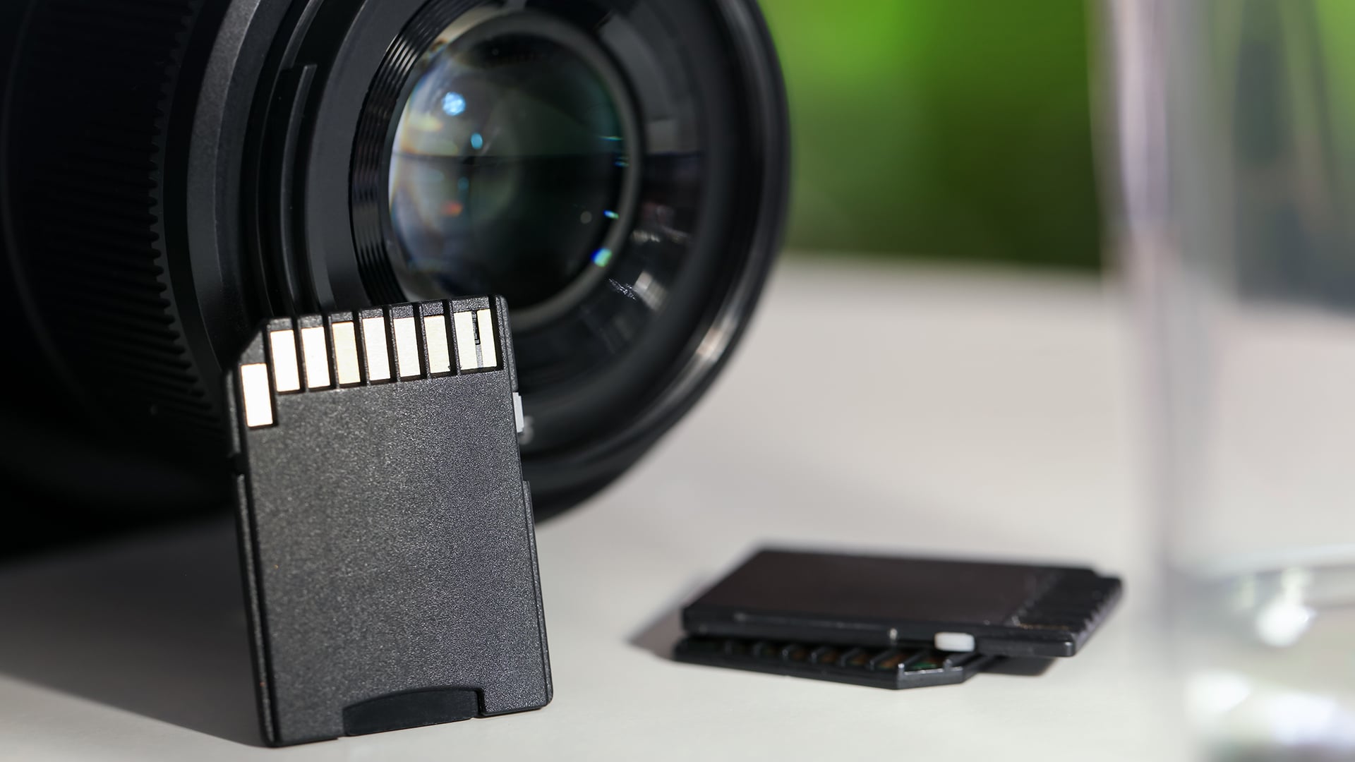 SD memory cards and photo camera on white table, closeup