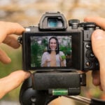 Unrecognizable camera operator shooting video with Asian farmer telling about healthy organic food for blog