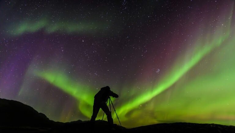 How to Shoot in Low Light: Simple Tips for Better Photos photographer and aurora borealis northern lights