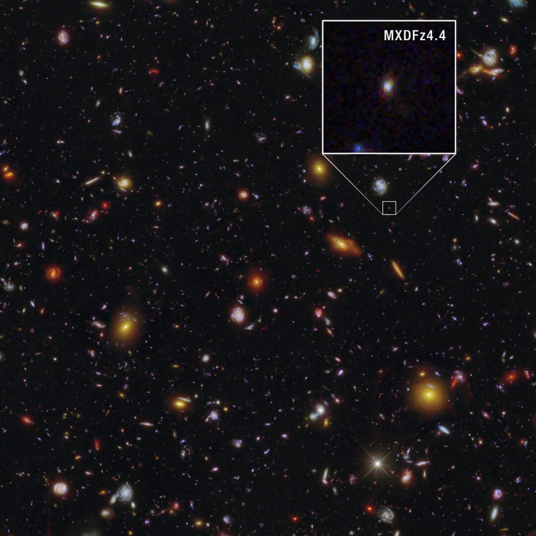 Hubble Ultra Deep Field (HUDF), captured by both the Hubble Space Telescope and the James Webb Space Telescope with  the galaxy MXDFz4.4, enlarged at right. Credit: NASA, ESA, STScI, I. Goovaerts, M. Rafelski, A. Koekemoer (STScI). Image Processing: A. Pagan (STScI)