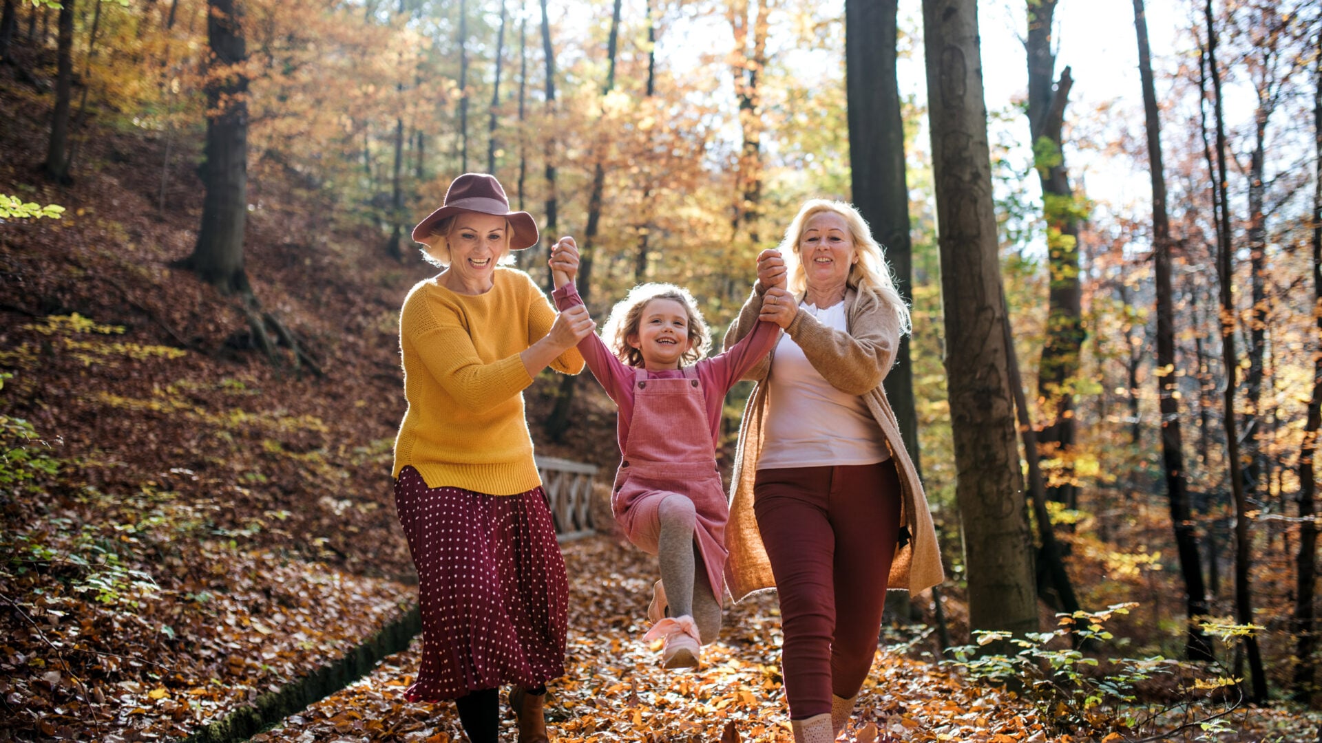 Simple Family Photography Tips for Natural Shots two women and child walking through forest autumn