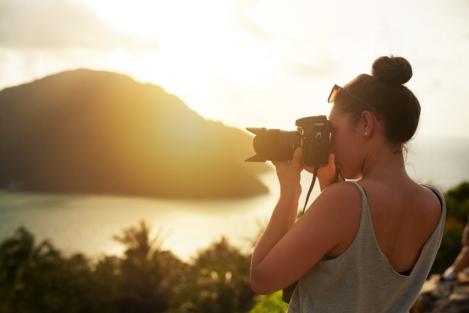 What's the Best Camera for Professional Photography in 2026? woman taking a photo at golden hour in nature