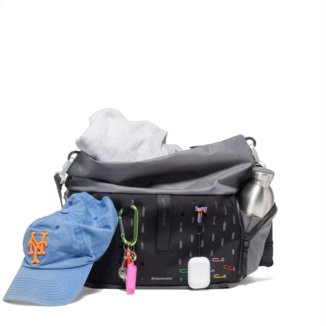 The Manfrotto UNCOVER Messenger bag pictured with with several person items affixed using the FlexGrid webbing.