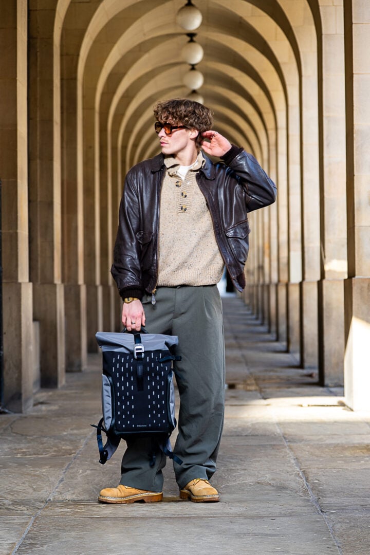 A man taking holding a grey Manfrotto UNCOVER Backpack.