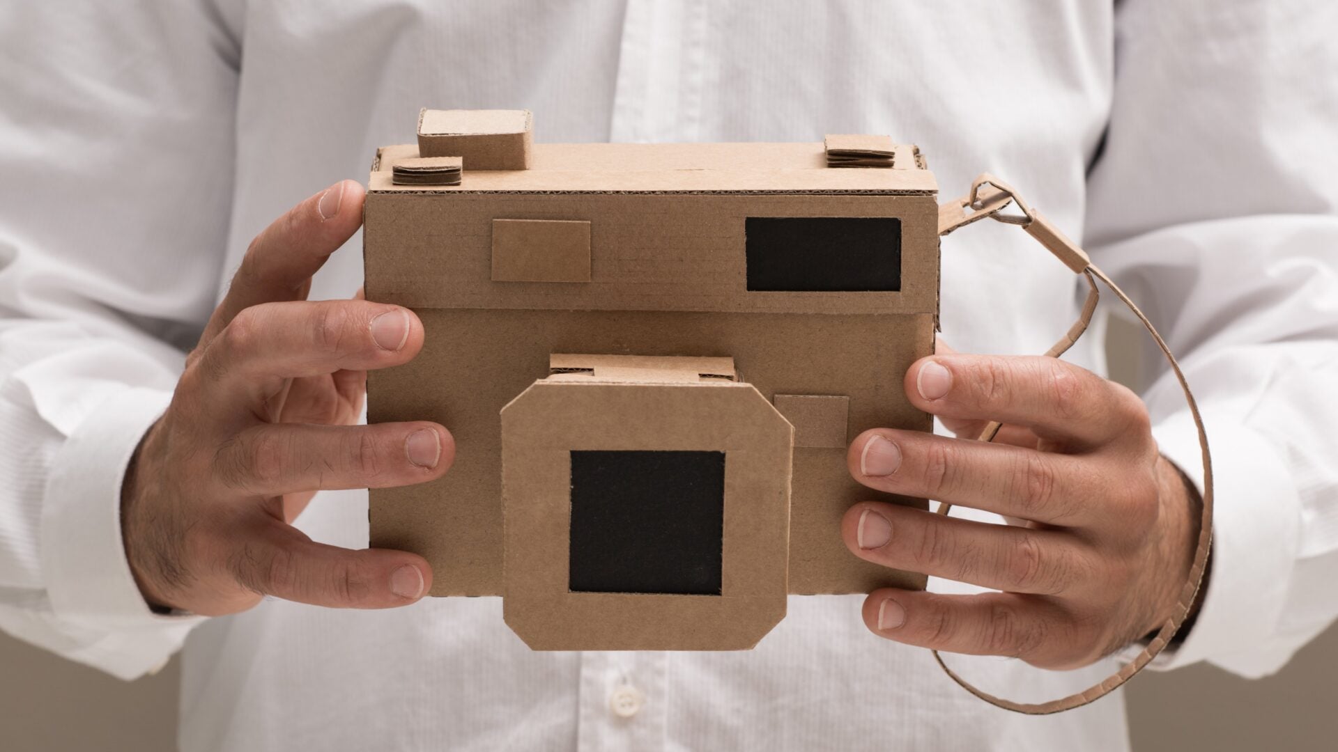 Photographer holding an handmade eco-friendly cardboard camera, crafts and creativity concept