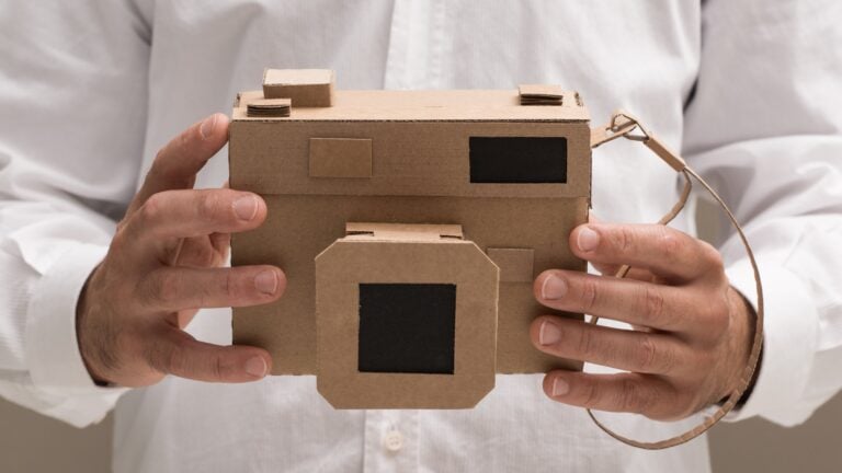 Photographer holding an handmade eco-friendly cardboard camera, crafts and creativity concept