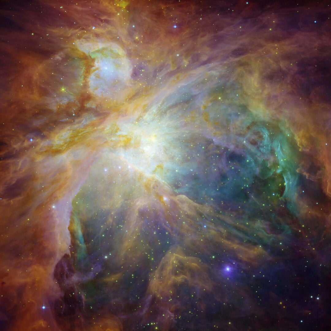 This image from NASA’s Spitzer and Hubble Space Telescopes shows the Orion Nebula in an explosion of infrared, ultraviolet, and visible-light colors. Credit: NASA