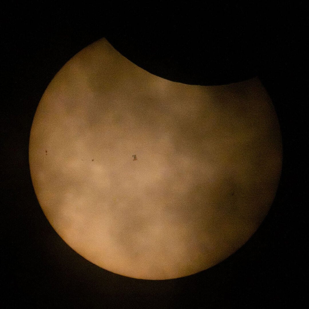 The International Space Station can be seen in this image transiting the sun during the eclipse. Credit: NASA/Joel Kowsky