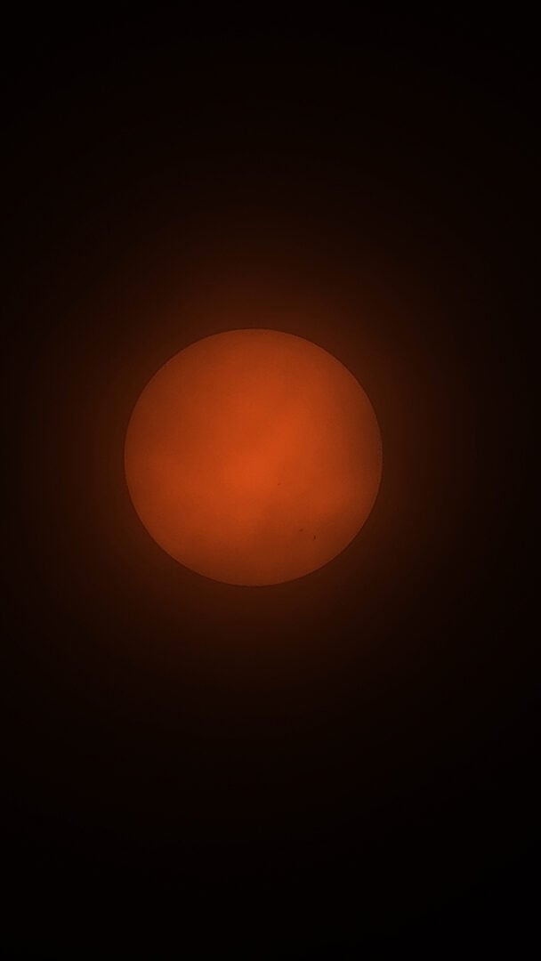 The sun captured through clouds. You can see sunspots towards the bottom-right edge