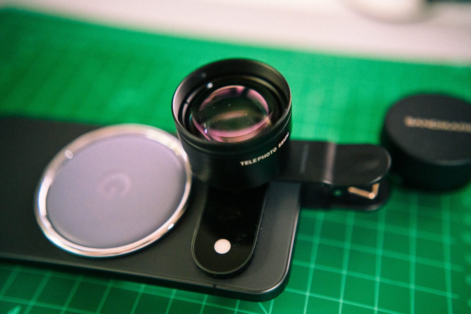A closeup image of the SANDMARC 58mm Telephoto Lens on a Google Pixel 11 Pro with the included Clip-on Mount.