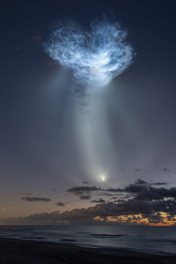 The exhaust plumes of a SpaceX Falcon 9 rocket carrying the company’s Dragon spacecraft are seen illuminated by sunlight against the predawn sky during the launch of NASA’s SpaceX CRS-35 mission. Credit: NASA/John Kraus